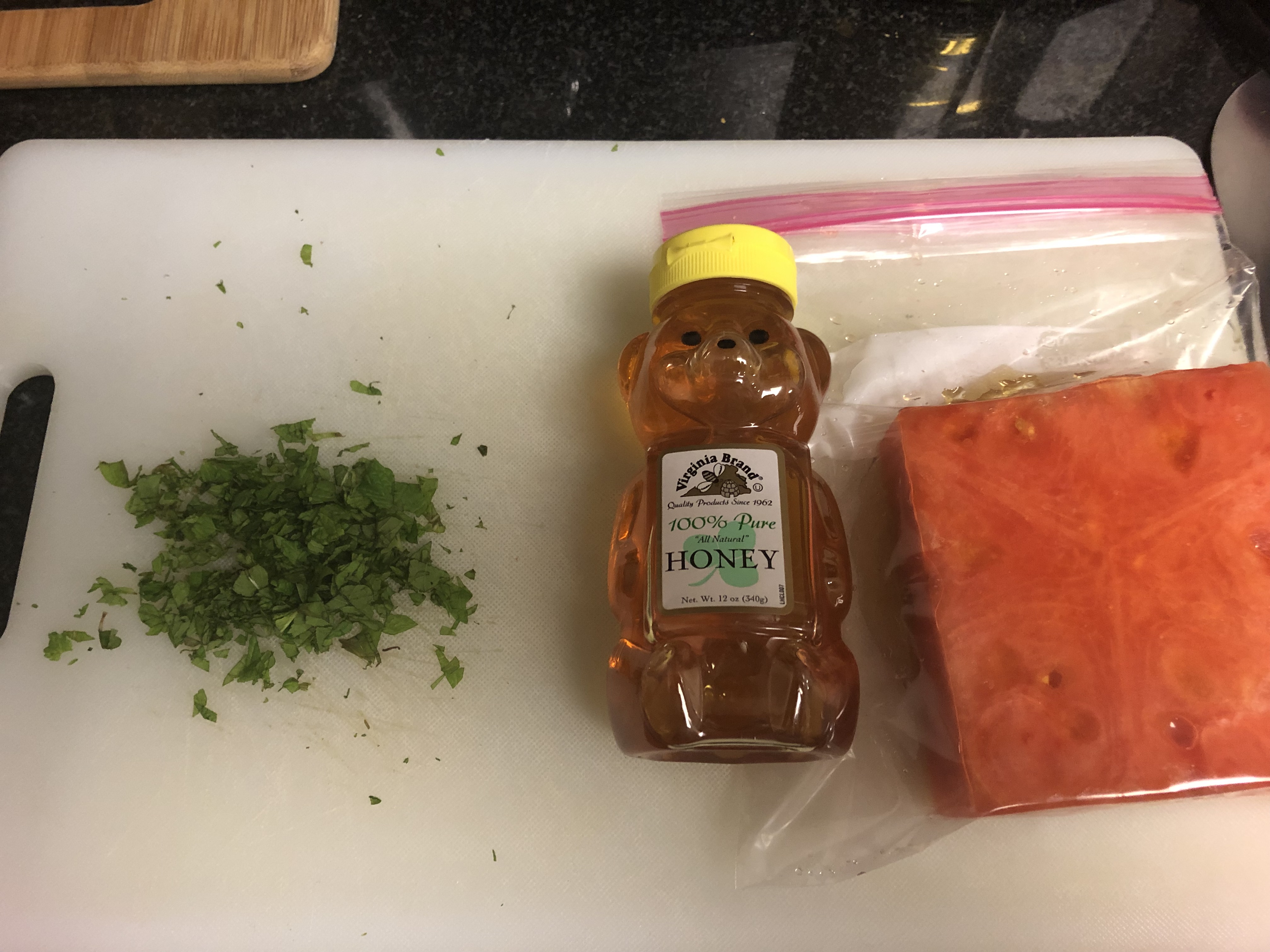 Watermelon in sandwich bag with honey next to chopped mint