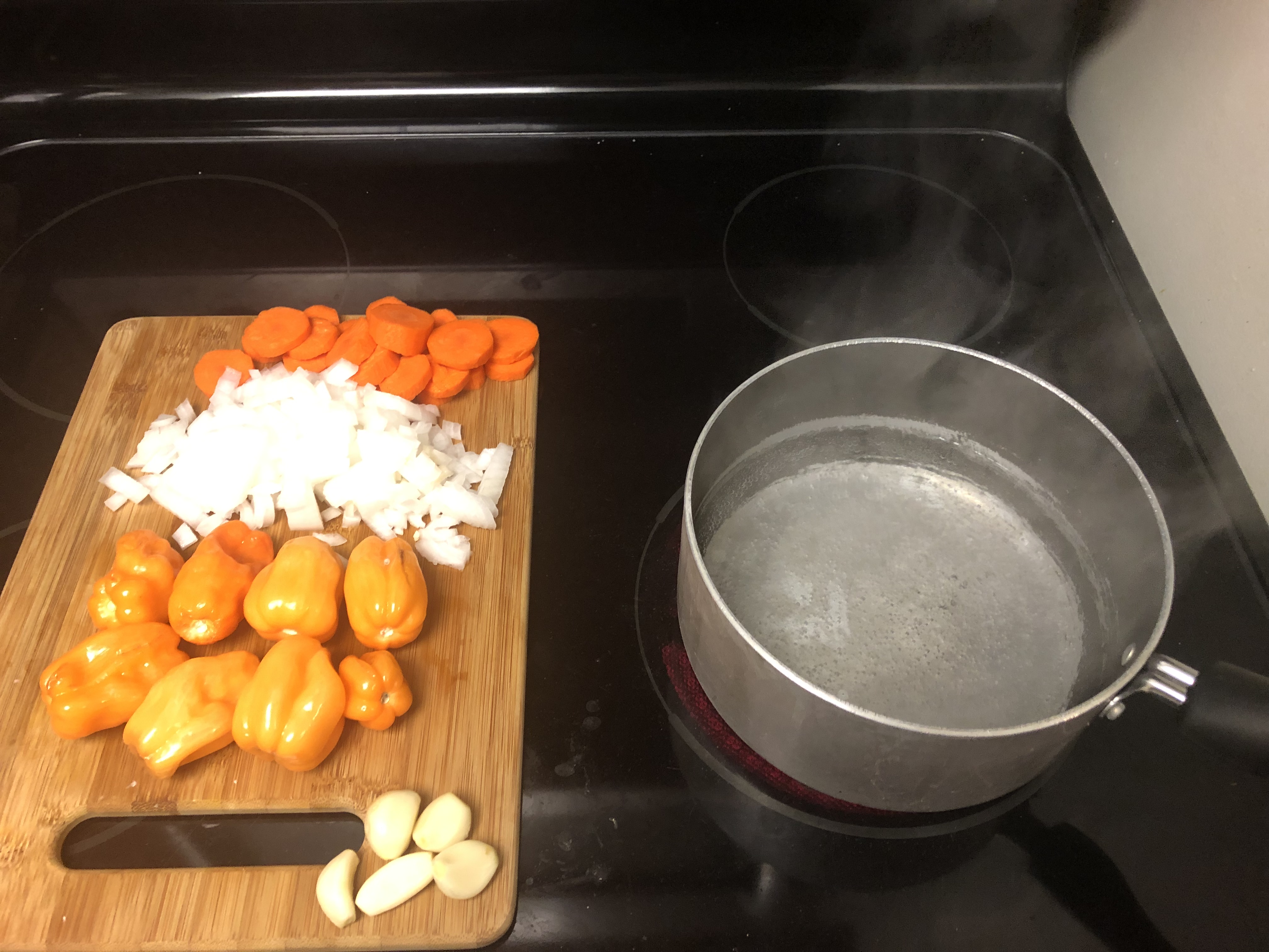 Prepped ingredients on cutting board next to pot of boiling water