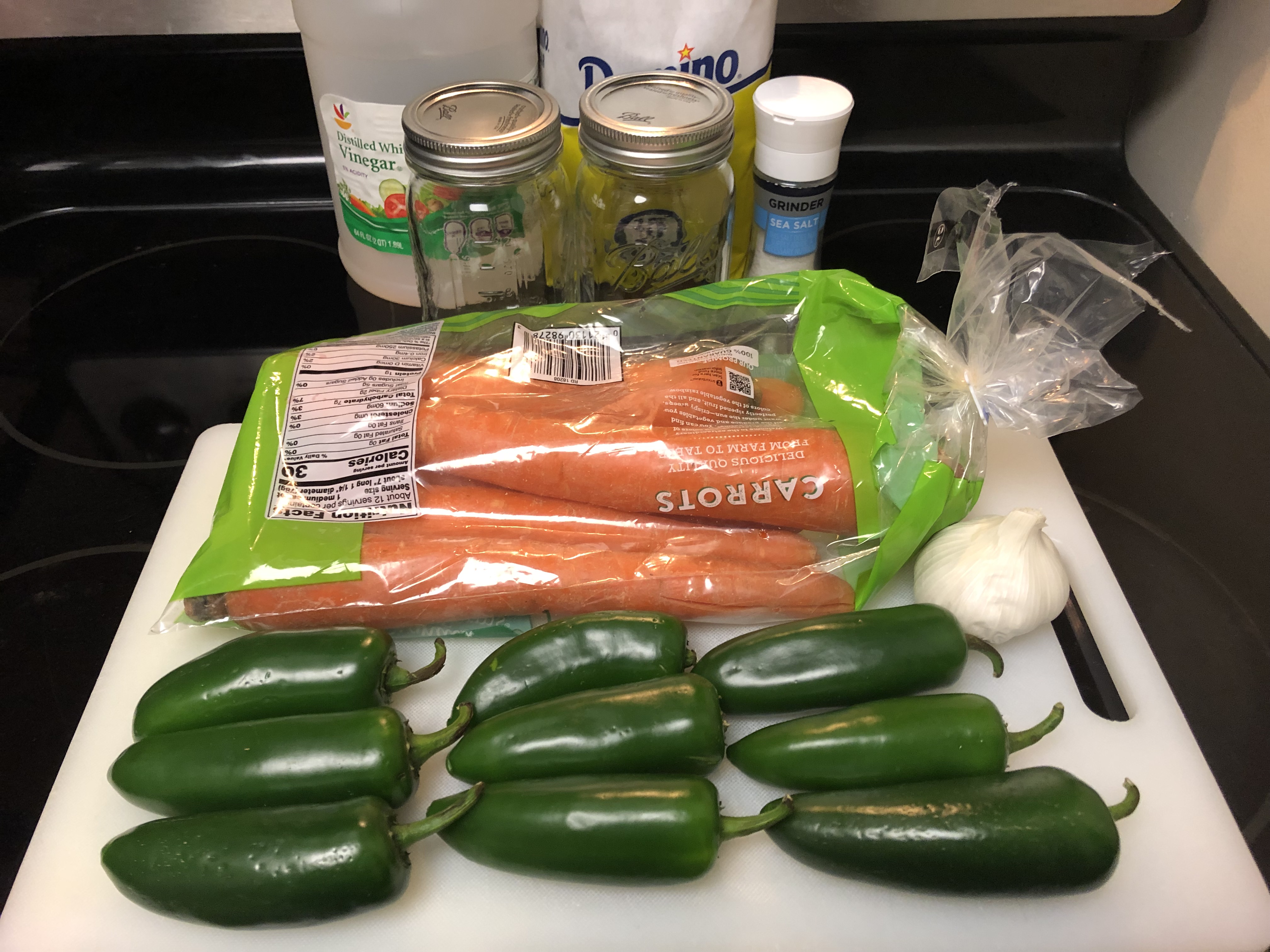 Ingredients for pickled jalapenos organized and laid out on stovetop