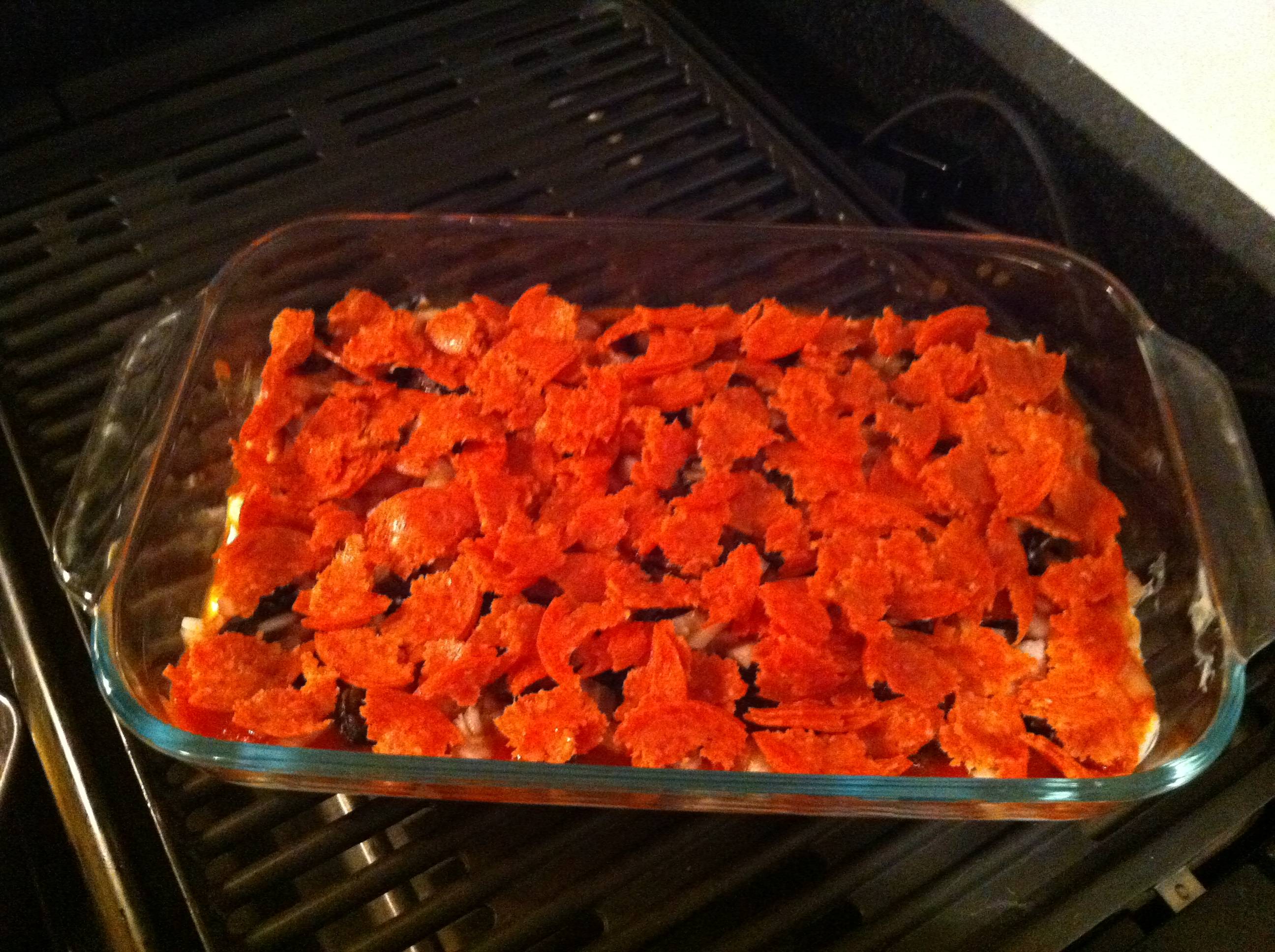 Torn pepperoni in baking pan
