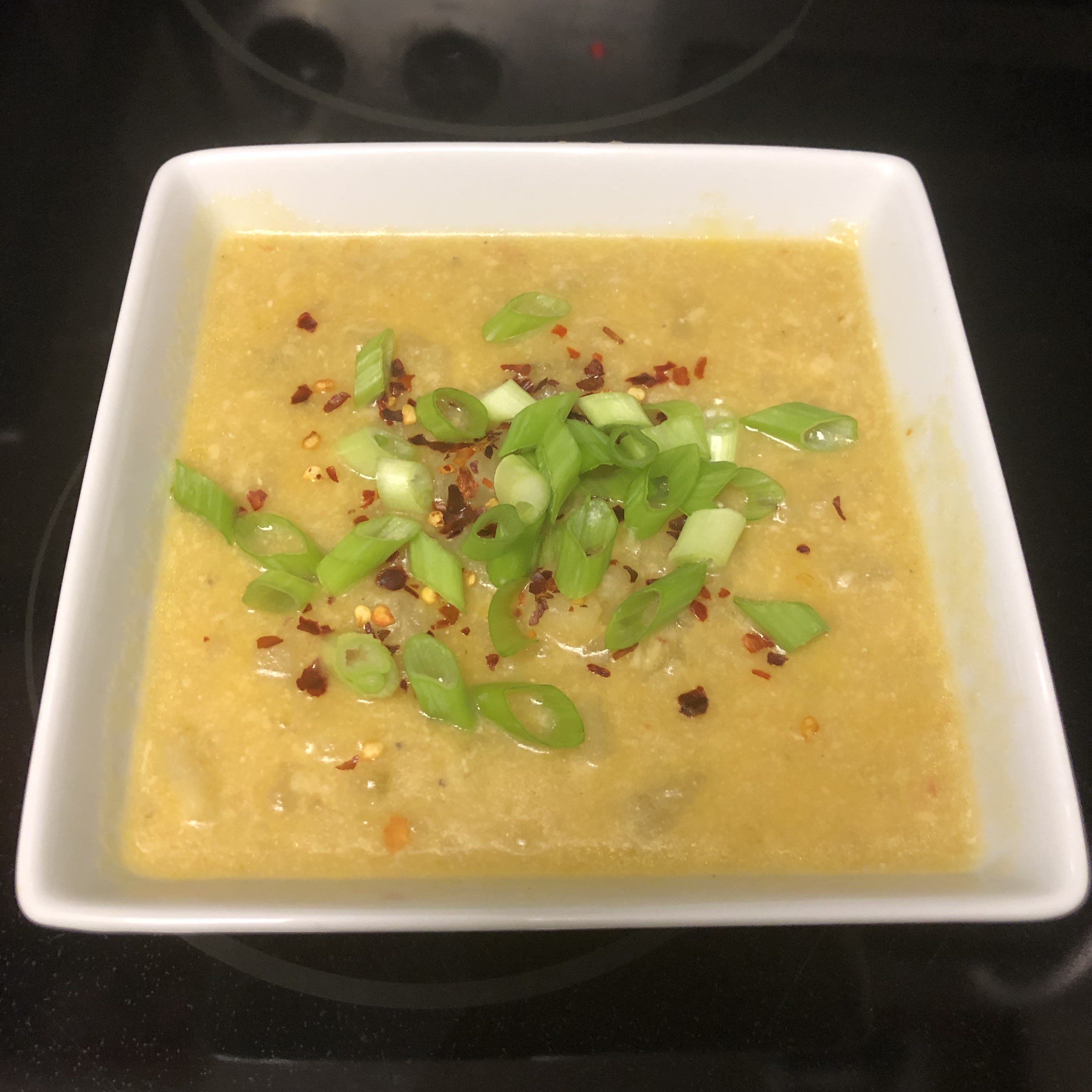 Finished soup garnished with crushed red pepper and scallions
