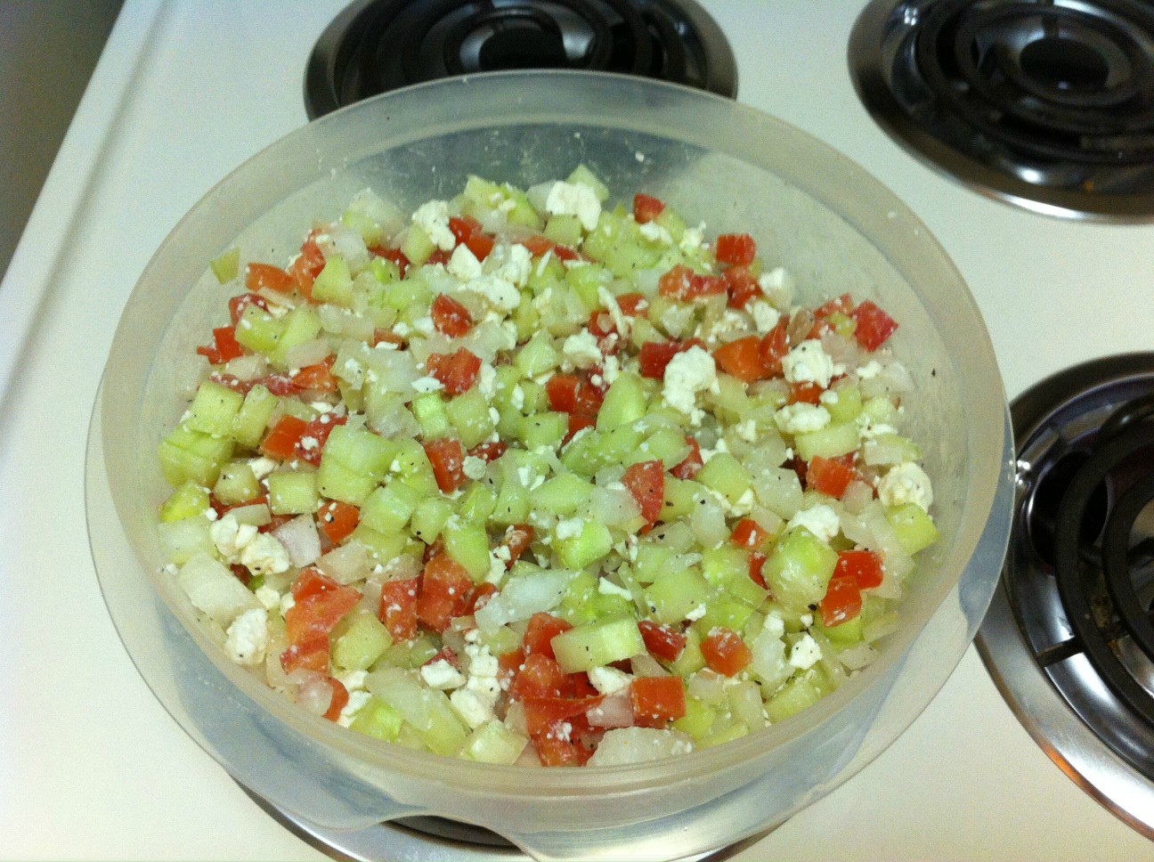 Complete Mediterranean Salad in tupperware container resting on stove